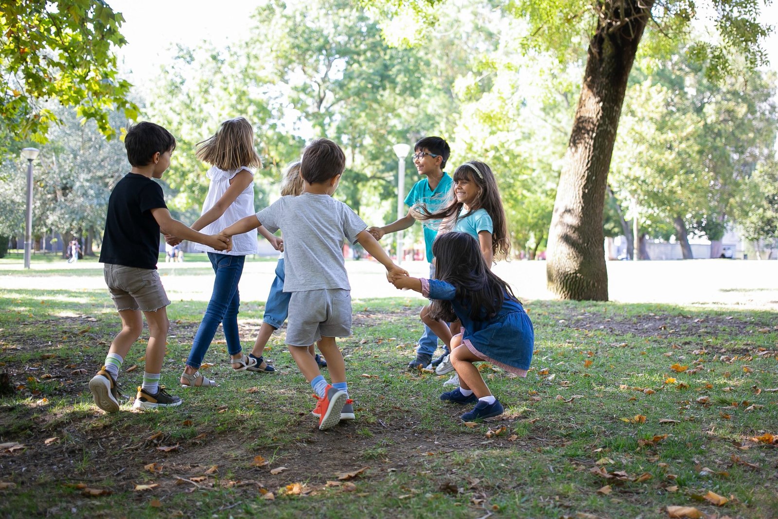 happy children playing together outdoors dancing around grass enjoying outdoor activities having fun park kids party friendship concept scaled