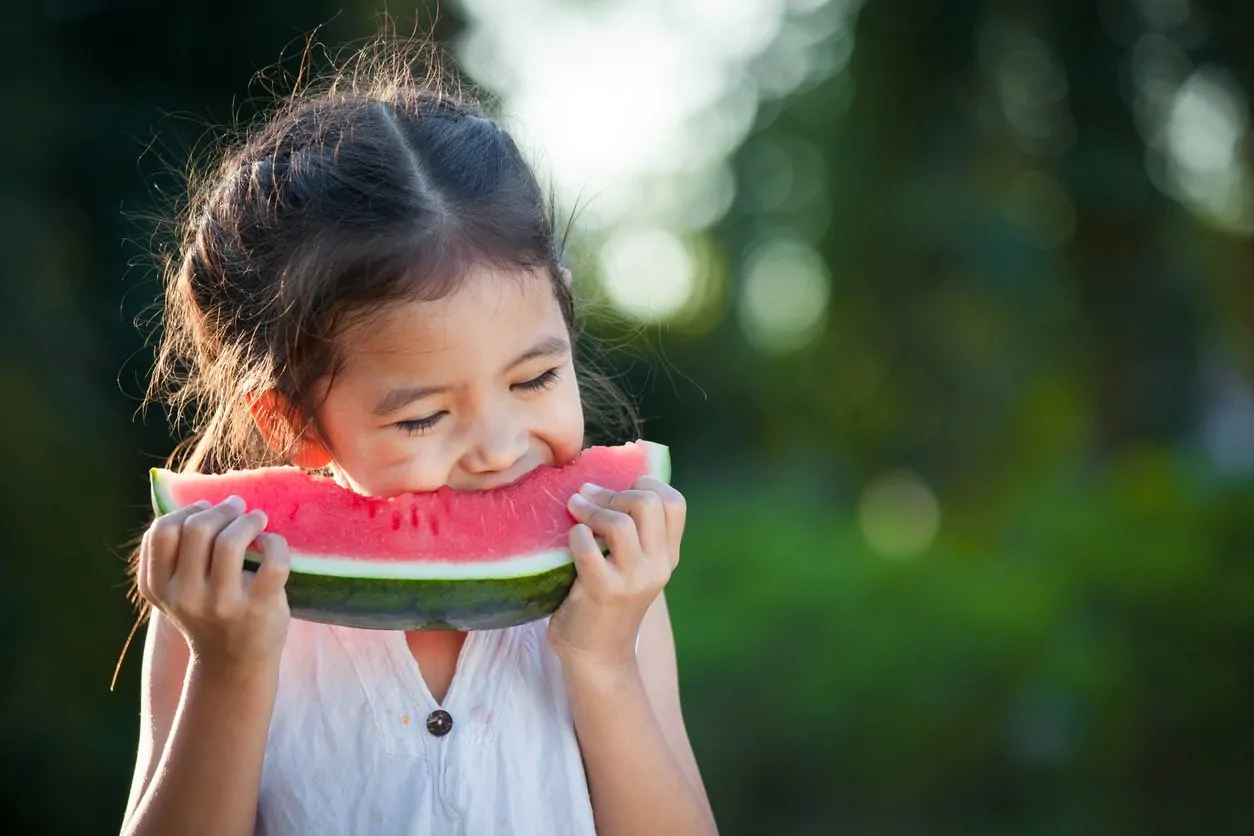 Cute asian little child girl eating watermelon